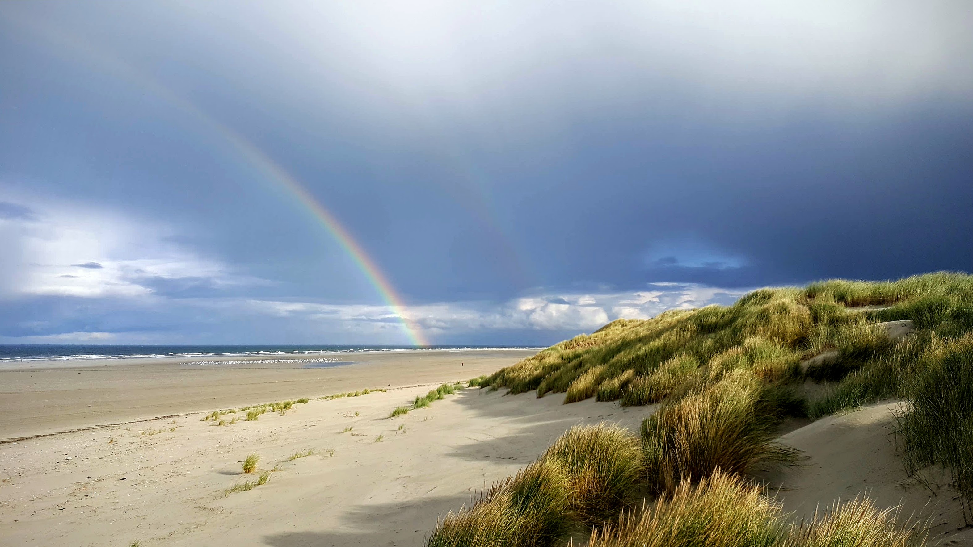 Terschelling strand Noordzee strand en duinen met regenboog op Terschelling