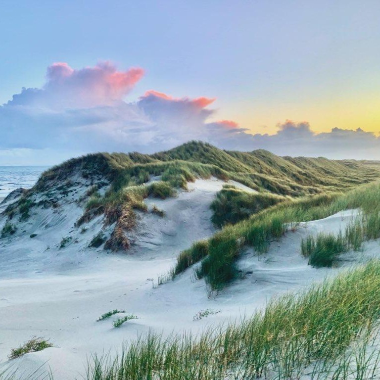 Schilderachtige luchten tijdens zonsondergang op Terschelling. De duinen van het Noordzee strand op Terschelling